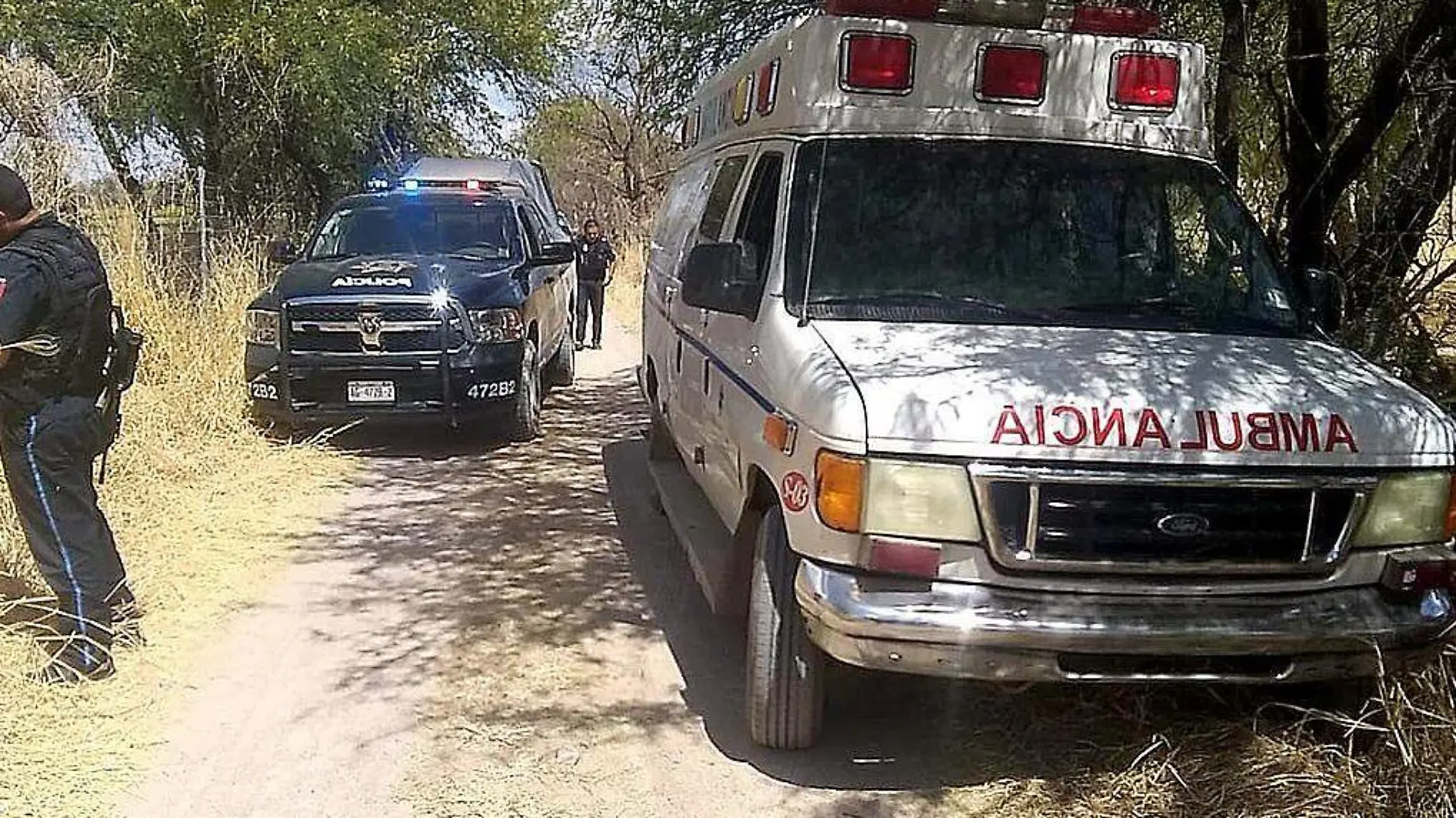 Patrulla y ambulancia en camino de terracería